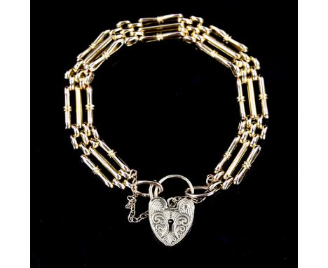 A late 20th century 9ct gold gate link heart padlock charm bracelet, hallmarks London 1977, bracelet length 18cm, 13.9gNo dam