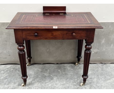 A George IV mahogany writing table, the leather inlet top with pen and ink well compartment, over a frieze drawer, raised on 