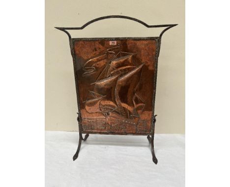 An Arts and Crafts copper and wrought iron firescreen, embossed with a sailing ship. 32' high