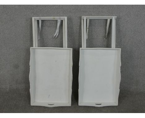 A pair of contemporary light grey painted butlers stands, the trays with pierced handles, on folding X stands. H.71 W.56 D.38