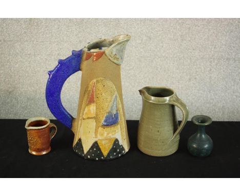 Three art pottery jugs and a blue glaze vase. One jug with abstract design by Jill Fanshawe-Kato with a blue glaze handle and