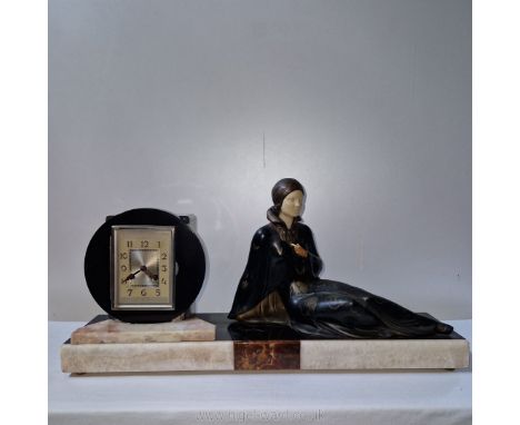 Manner of Menneville and Rochard, a 1920's art deco marble, spelter and ivorine clock, depicting a fashionable lady in a recl