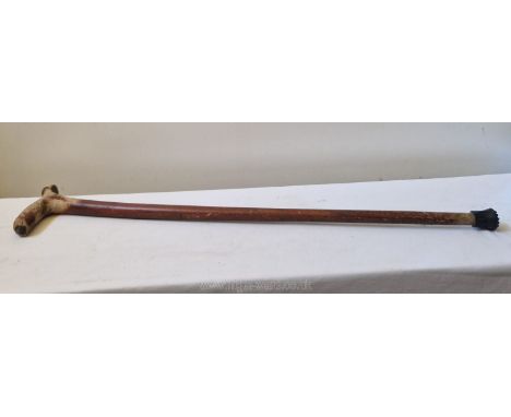 A characterful old country made walking stick carved from a single piece of wood, red paint heavily worn, 32 ins.