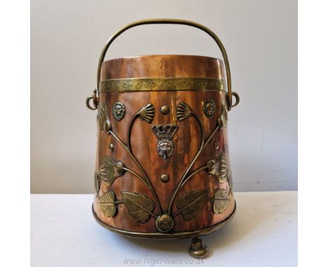 A very fine and interesting art nouveau copper coal bucket with swing handle and raised floral decoration in brass, English, 