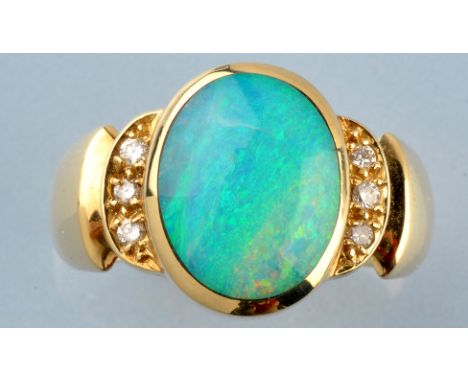 An opal and diamond ring, the oval opal cabouchon in collet setting, flanked by three brilliant cut diamonds to each shoulder