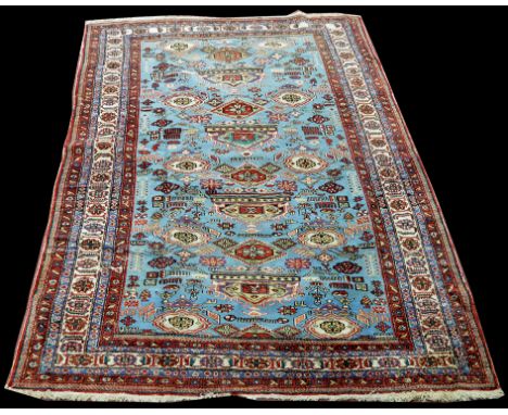 A Caucasian carpet, with medallions on light blue ground, 256 x 169cms (100 1/2 x 66 1/2in.).