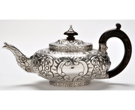 A George IV teapot, by Michael Starkey, London 1824, squat circular, profusely embossed withy scale work, flowers and scrolls