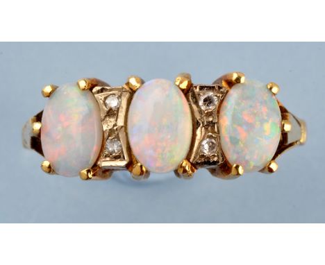 An opal and diamond ring, the three oval opal cabouchons separated by two pairs of diamonds, the yellow metal shank stamped '