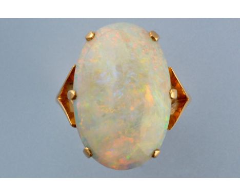 An opal ring, the oval opal cabouchon in six claw setting, on yellow metal shank stamped '18ct.', ring size L.