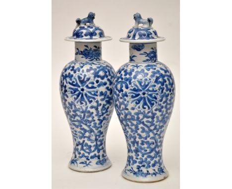 Pair of Chinese blue and white inverted baluster vases and covers, the bodies with lotus scrolls in two registers, buddhist l