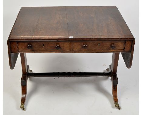 A Regency mahogany sofa table, the top and fall flaps with boxwood stringing and star motif above two frieze drawers opposite