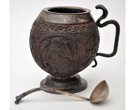 'Hindu' silver metal mounted coconut, the sides carved with figures within arcaded panels, with silver metal ladle, height 13