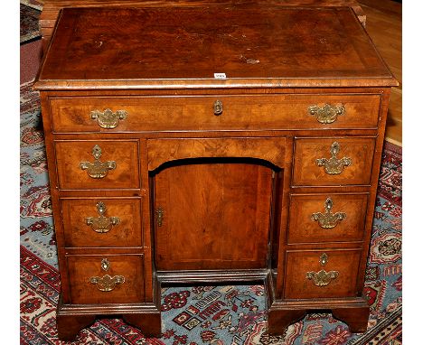 A George I style walnut kneehole desk, the rectangular top with herringbone stringing and crossbanding, above a single long a