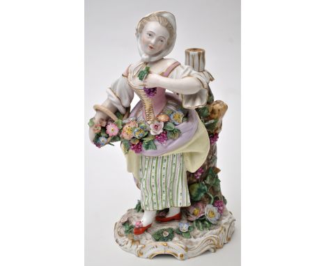 Meissen-style flower seller lamp holder, the figure with flowers in a basket and within her apron standing beside vine clad s