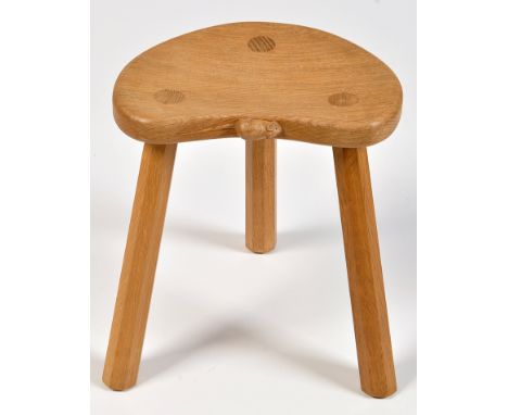 Robert "Mouseman" Thompson: an oak milking stool, the shaped seat with carved mouse motif raised on three tapering octagonal 