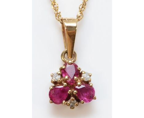 A 9ct gold diamond and three stone ruby pendant with a chain, 8mm across, 1.6g
