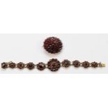 A low grade silver gilt Bohemian garnet cluster bracelet, lacking one link, 15cm and an oval brooch,