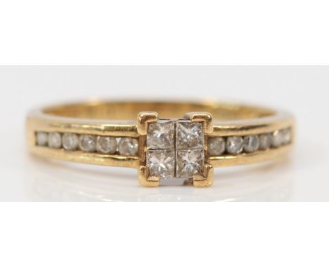 A 9ct gold and diamond ring, four Princess cut diamonds flanked by brilliant cut diamond set shoulders, K 1/2, 2g