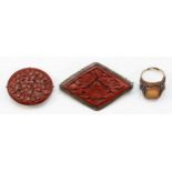 A Chinese silver enamel and hardstone ring, and two silver mounted cinnabar lacquer brooches, 19gm