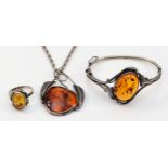 A 925 silver and amber hinged bangle, 55 x 45mm, a silver and amber ring, and a silver and amber