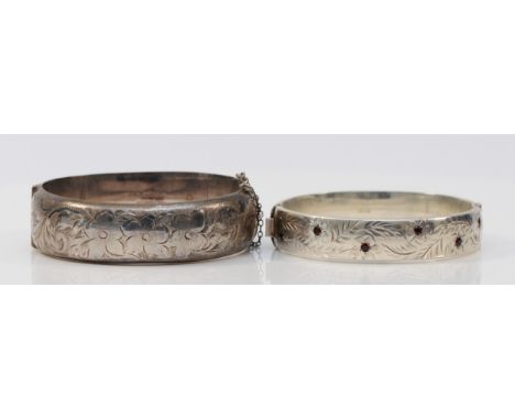 A silver hinged bangle, Birmingham 1974 and another inset with red glass, 51gm