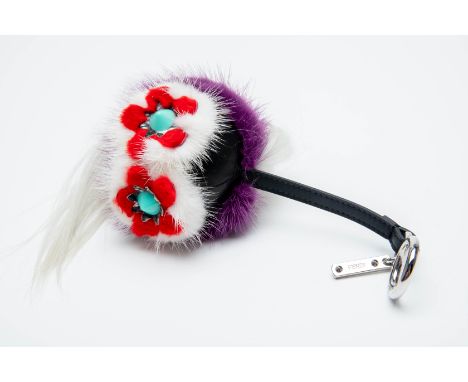 A FENDI FLOWER MINI BAG BUG CHARM
With pink goat fur around the pyramid shaped eyes, a light blue mohawk, and purple goat fur