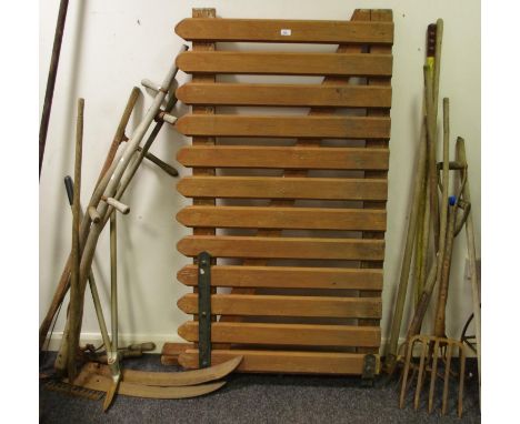 Tools - two scythes; hoes; tree loppers; rake; forks; garden gate; cannon barrel brush.