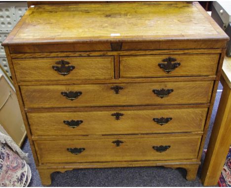 A George III crossbanded oak chest, rectangular top above two short and three long graduated drawers, swing handles, tall bra