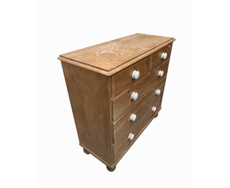 A pine chest of drawers, with two short and three long drawers, on turned bun feet, height 102cm, width 103cm, depth 44cm.Con