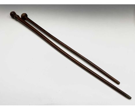 A lignum vitae cane, with turned knop, together with a further cane with carved finial, length 86cm (2).
