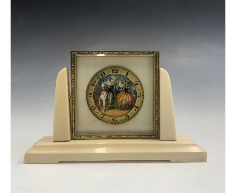 A 1920s ivory and gilt metal Swiss boudoir timepiece, the dial painted with a lute player serenading two ladies, with a dog a