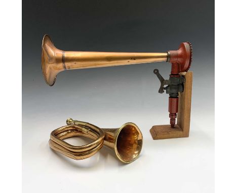 A vintage ships copper horn, length 40cm, on wooden stand, together with a copper and brass bugle and a copper and brass ship