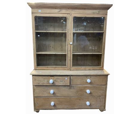A pine bookcase, with a pair of glazed doors above two short and two long drawers, height 196cm, width 138cm, depth 45cmCondi