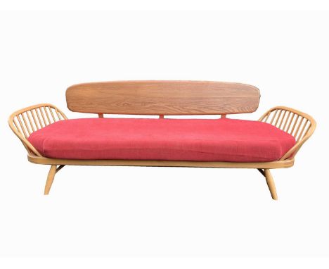 An Ercol beech framed daybed/studio couch, with detachable elm back rest and stick ends, original upholstered cushion cover, 