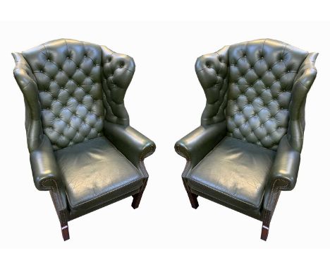 A pair of George III style green leather wing armchairs, by Wade, with a button back, padded and arms and seat on square moul
