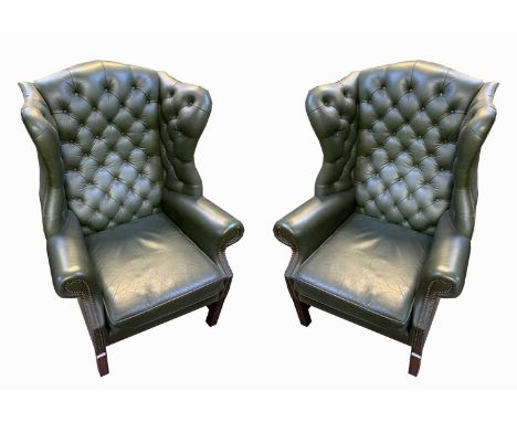 A pair of George III style green leather wing armchairs, by Wade, with a button back, padded and arms and seat on square moul