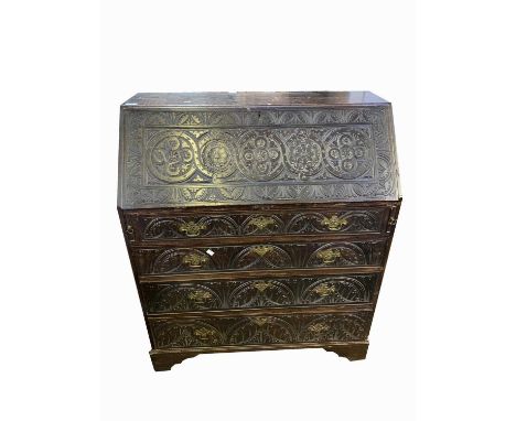 AGeorge III carved oak bureau, the fall front opening to revela a fitted interior, above four long graduated drawers, on brac