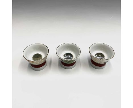 Three Japanese Saki cups, 20th century, each with a magnified image of European naked ladies to the base, diameter 5cm.