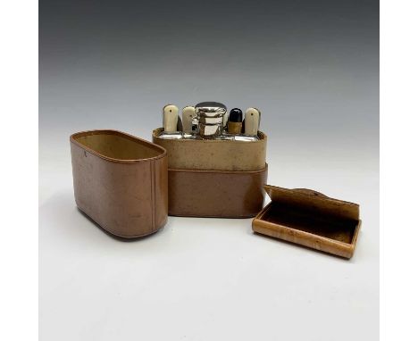 An early 20th century leather cased travel set, containing a spirit flask with two detachable cups, two folding knives, and t