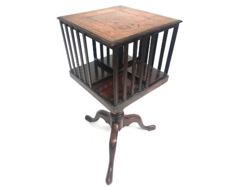 A mahogany revolving book stand, with leather inset top and slatted end supports, raised on a George III baluster turned pill
