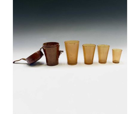 A set of 19th century graduated horn cups, the largest 11cm high, contained in a leather holder, initialled S.G.H., height 13