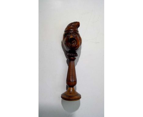 A 19th century fruitwood nutcracker, carved with a double-sided head in nightcap, the nut receptacle in the form of an open-m