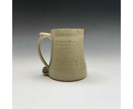 A Leach studio pottery mug, the handle with scroll terminal. Height 11.5cm.