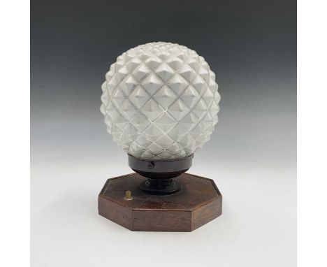 An Art Deco table lamp, with walnut segment veneered octagonal base and fitted with a 'pineapple, glass shade, height 23cm.