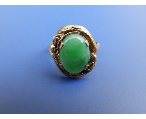 A Chinese yellow metal dragon ring set with jade coloured cabochon.