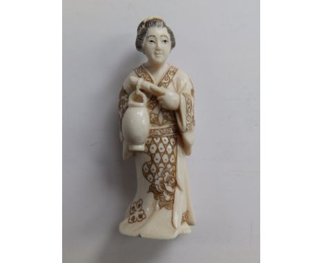 A Japanese signed ivory netsuke depicting a Bijin holding a lantern, 2.4”