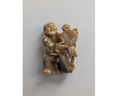 A Japanese signed ivory netsuke depicting a man holding a mallet with a rat at his feet, 1.75”