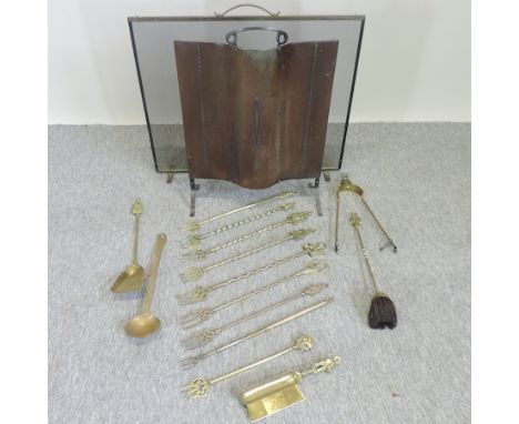 An early 20th century brass fire screen, together with another and a collection of brass fire tools