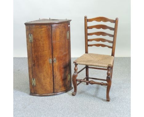 A George III oak bow front hanging corner cabinet, 60cm wide, together with a 19th century oak ladder back dining chair