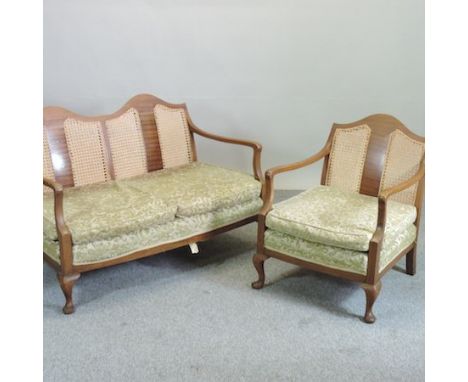 An early 20th century sofa, with a single cane back and green cushions, 120cm, together with a pair of matching armchairs